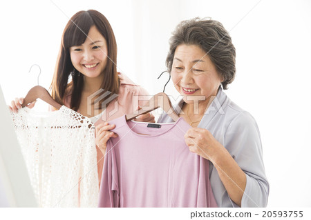 選擇衣服的高級婦女和年輕婦女 20593755