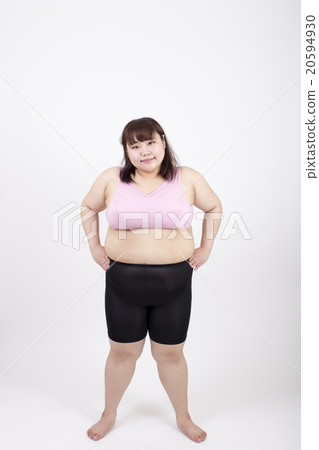 A young woman who is looking at the camera with his hands on his waist in front of a white background 20594930