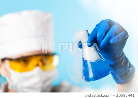 Woman chemist examines test tube Woman chemist examines test tube 20595441