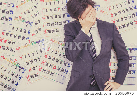 A businessman troubled in front of the calendar 20599070