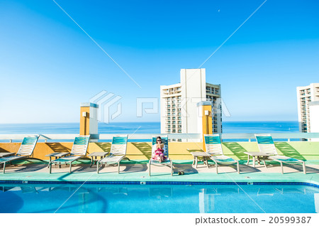 Asian lady who is relaxing at the resort hotel's poolside 20599387