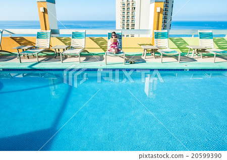 Asian lady who is relaxing at the resort hotel's poolside 20599390