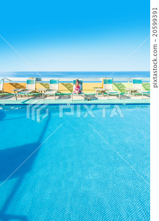 Asian lady who is relaxing at the resort hotel's poolside 20599391