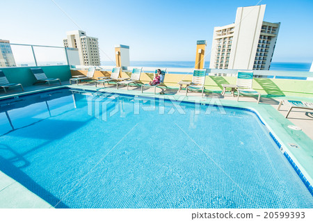 Asian lady who is relaxing at the resort hotel's poolside 20599393