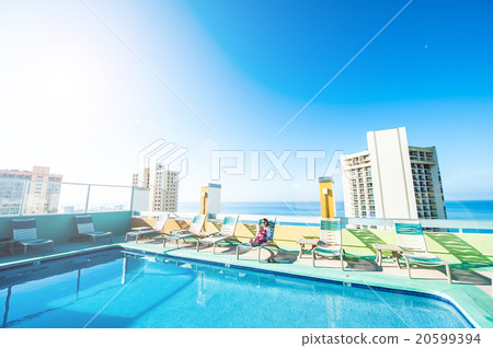 Asian lady who is relaxing at the resort hotel's poolside 20599394