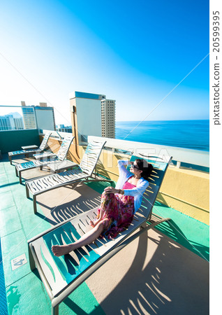 Asian lady who is relaxing at the resort hotel's poolside 20599395