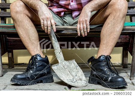 mason with hairy legs in boots resting on a bench 20603102