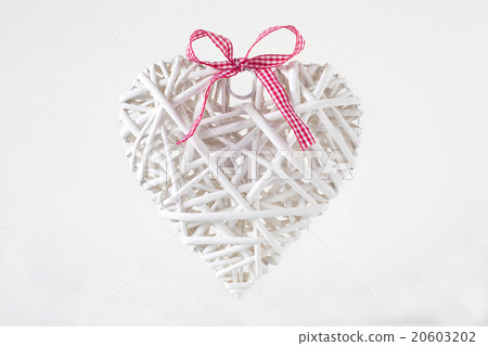 White heart made of  branches with a red ribbon 20603202