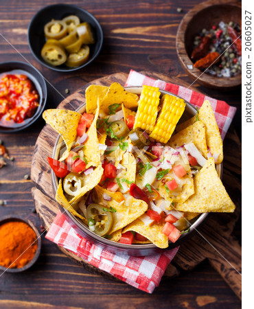 Nachos, cheese sauce, salsa and corn cobs Top view 20605027