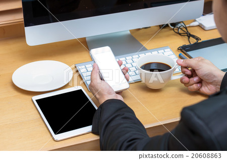 Rear view of a businessman working with a computer and tablet wh 20608863