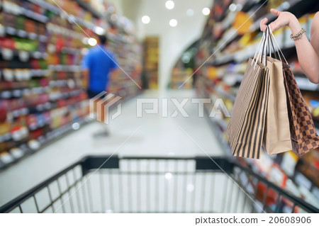 Holding shoping bags by hand on Supermarket with Abstract blurre Holding shoping bags by hand on Supermarket with Abstract blurre 20608906