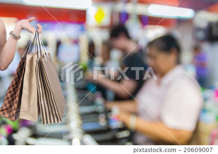 Holding shoping bags by hand on Abstract blurred photo of store 20609007