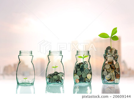 Mix coins and seed in clear bottle on cityscape photo blurred ci Mix coins and seed in clear bottle on cityscape photo blurred ci 20609144