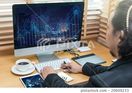 Rear view of a businessman working with a computer and tablet of Rear view of a businessman working with a computer and tablet of 20609233