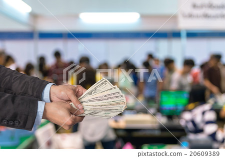 Businessman offered the money on Abstract blurred photo of cashi 20609389
