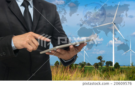 Businessman using the tablet on Wind turbine power generator on 20609576