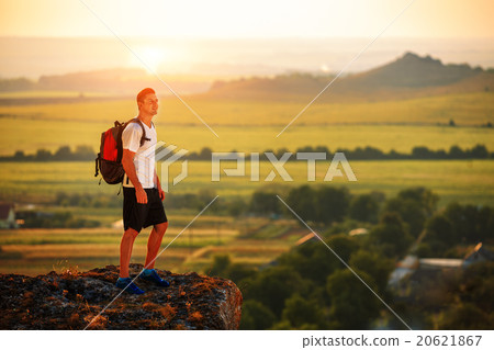 Hiker with backpack standing on top of a mountain 20621867