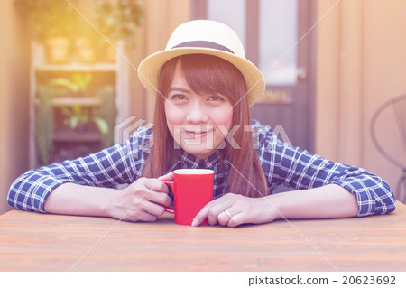 wear hat woman sitting in outdoor with warm drink wear hat woman sitting in outdoor with warm drink 20623692