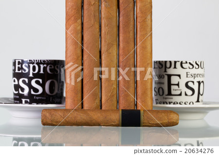 Different cigars and cups of coffee on glass table 20634276