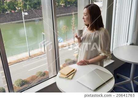 二十多歲的女人站在桌子前面 20641763