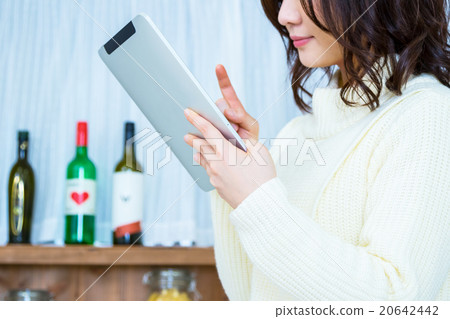 Woman's hand at hand operating tablet PC in kitchen White kitchen Kitchen Cookery Recipe search Menu Search 20642442