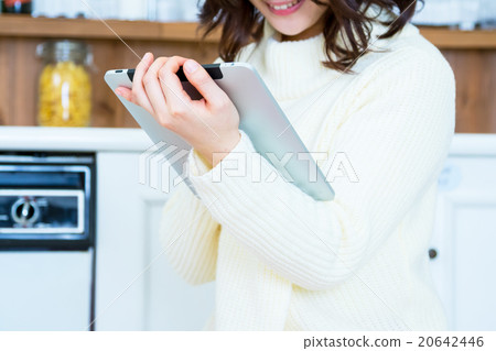 Woman's hand at hand operating tablet PC in kitchen White kitchen Kitchen Cookery Recipe search Menu Search 20642446