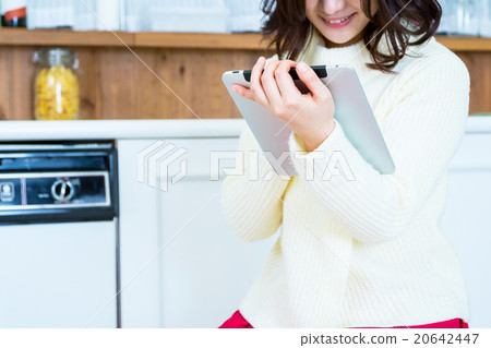 Woman's hand at hand operating tablet PC in kitchen White kitchen Kitchen Cookery Recipe search Menu Search 20642447