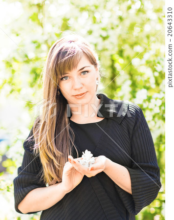 Beautiful young woman over white blossom tree Beautiful young woman over white blossom tree 20643310