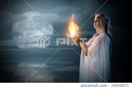 Elven girl holding fire in palms at sea shore 20650075