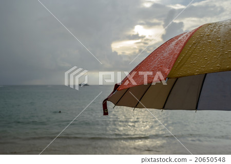 Colorful umbrella in the rain and blur beach  20650548