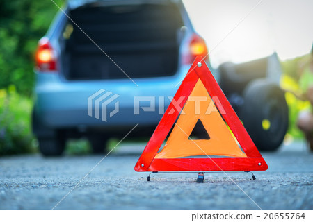 Changing the tire on a broken down car on a road  20655764