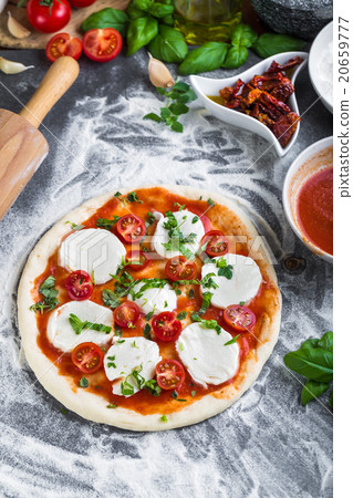Prepering margherita pizza with mozzarella Prepering margherita pizza with mozzarella 20659777