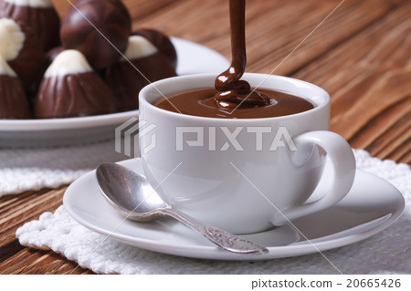 Chocolate is poured into a cup closeup 20665426