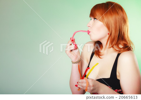 Redhair girl holding sweet food jelly candy on green. Redhair girl holding sweet food jelly candy on green. 20665613