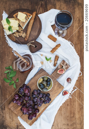 Glass of red wine, cheese board, grapes, walnuts 20669699