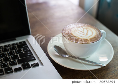 Hot latte and laptop on wooden table Hot latte and laptop on wooden table 20678294