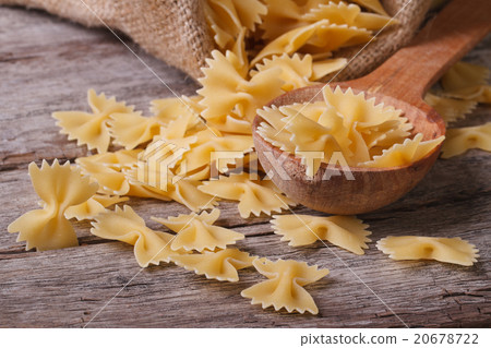 farfalle pasta macro dry on a wooden spoon farfalle pasta macro dry on a wooden spoon 20678722