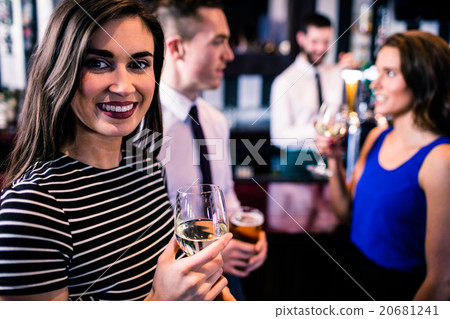 Portrait of woman having a drink with friends Portrait of woman having a drink with friends 20681241