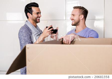 Smiling gay couple drinking red wine 20681358