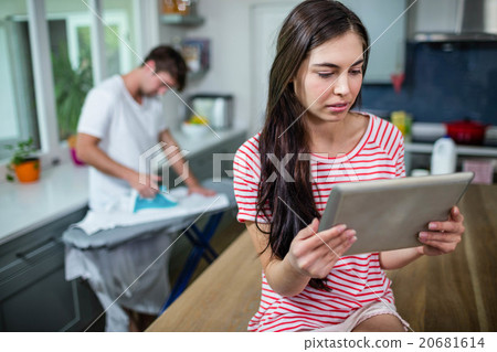 Brunette using tablet in kitchen 20681614