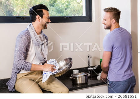 Smiling gay couple washing dishes 20681651