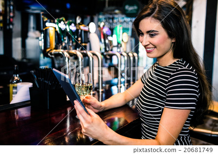 Woman using tablet and having a glass of wine Woman using tablet and having a glass of wine 20681749