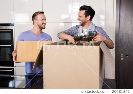Smiling gay couple unpacking cardboard 20681841