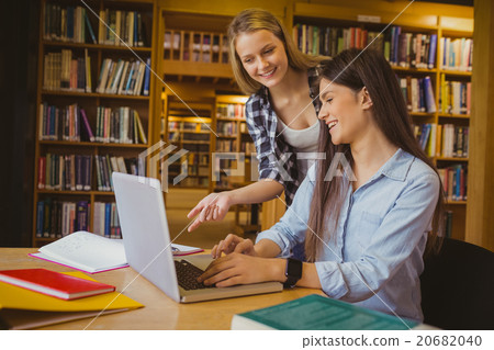 Smiling students using laptop 20682040