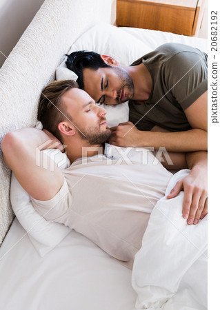 Happy gay couple sleeping together on bed Happy gay couple sleeping together on bed 20682192