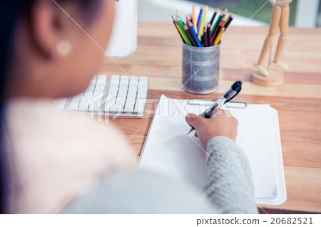 Over shoulder view of woman writing on white sheet 20682521