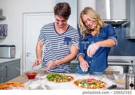 Smiling couple preparing pizza Smiling couple preparing pizza 20682592