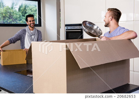 Smiling gay couple unpacking cardboard 20682653