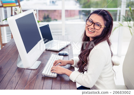 Smiling Asian woman working on computer 20683002