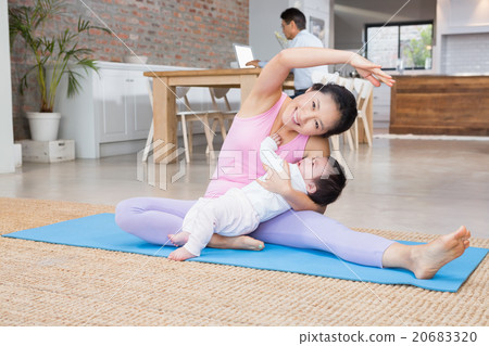 Happy mother and baby daughter exercising on mat Happy mother and baby daughter exercising on mat 20683320